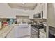 Kitchen features white cabinets, mosaic backsplash, stainless steel appliances, and granite countertops at 1905 Canterbury Ln # 17, Sun City Center, FL 33573