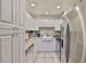 Well-lit kitchen featuring white cabinets, stainless steel appliances, farmhouse sink, and granite countertops at 1905 Canterbury Ln # 17, Sun City Center, FL 33573