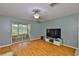 Bright living room features hardwood floors, ceiling fan, and sliding glass doors leading to a screened-in patio at 1905 Canterbury Ln # 17, Sun City Center, FL 33573