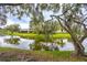 Lush backyard landscaping with a picturesque view of the calm lake at 200 Gretchen Ct, Oldsmar, FL 34677