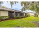 Back exterior view with well-manicured lawn, bushes, and lovely screened in porch at 200 Gretchen Ct, Oldsmar, FL 34677