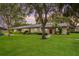 Charming home featuring lush landscaping and a convenient covered parking area, all set against a picturesque sky at 200 Gretchen Ct, Oldsmar, FL 34677