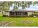 Charming back exterior with screened-in porch, and flourishing landscaping at 200 Gretchen Ct, Oldsmar, FL 34677