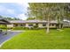 Charming single-story home featuring a well-manicured lawn and lush landscaping, complemented by a convenient covered parking area at 200 Gretchen Ct, Oldsmar, FL 34677
