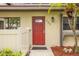 Close-up of front door with red finish, address number, and small palm trees at 200 Gretchen Ct, Oldsmar, FL 34677