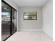 Open living room with neutral colors, tile floors, and a sliding glass door for natural light at 200 Gretchen Ct, Oldsmar, FL 34677