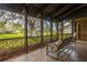 Relaxing screened-in patio with comfortable seating and views of the pond and mature trees at 200 Gretchen Ct, Oldsmar, FL 34677