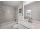 Bathroom with a bathtub and shower combination and large, bright mirror at 210 Lake Hobbs Rd, Lutz, FL 33548