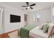 Cozy bedroom featuring mounted television, ceiling fan, and bright window at 210 Lake Hobbs Rd, Lutz, FL 33548