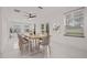 Bright dining room featuring modern lighting fixture, neutral walls and tile flooring at 210 Lake Hobbs Rd, Lutz, FL 33548