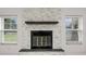 Modern fireplace with a stone surround and a dark wood mantel, flanked by windows at 210 Lake Hobbs Rd, Lutz, FL 33548