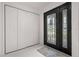 Bright foyer featuring sleek white tile flooring, a modern front door, and a spacious coat closet at 210 Lake Hobbs Rd, Lutz, FL 33548