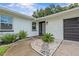 Inviting front entrance with decorative stone landscaping and a modern glass-paneled door at 210 Lake Hobbs Rd, Lutz, FL 33548