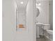 Bright hallway leads to a bathroom with pedestal sink and gray flooring at 210 Lake Hobbs Rd, Lutz, FL 33548