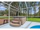 A relaxing hot tub is located under a screened enclosure near the pool at 210 Lake Hobbs Rd, Lutz, FL 33548