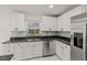 Well-lit kitchen featuring stainless steel appliances, dark countertops and bright white cabinetry at 210 Lake Hobbs Rd, Lutz, FL 33548