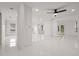 Bright open-concept living area showcasing pristine white tile flooring, multiple windows, and neutral decor at 210 Lake Hobbs Rd, Lutz, FL 33548