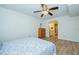 Comfortable bedroom with ensuite bathroom, ceiling fan, wood-look flooring and light, neutral paint at 2206 Cordova Grn # 2206, Seminole, FL 33777