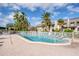 Community pool with plenty of lounge chairs and palm trees against a blue, sunny sky at 2206 Cordova Grn # 2206, Seminole, FL 33777