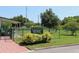 Gated community dog park with lush green grass and mature trees provides a safe play area for furry friends at 2460 Persian Dr # 44, Clearwater, FL 33763