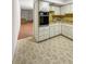 Kitchen featuring white cabinets and dated appliances overlooking living room at 2460 Persian Dr # 44, Clearwater, FL 33763