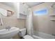 Bathroom with tiled walls, toilet, a tub and shower with shower curtain, sink and mirror at 2518 Keen Park Dr, Largo, FL 33771