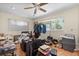 Cluttered room with wood floors, ceiling fan, window, a chair, and overflowing with household items at 2518 Keen Park Dr, Largo, FL 33771
