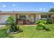 Cozy single-story home showcasing a brick accent, front porch seating, and neat landscaping at 2518 Keen Park Dr, Largo, FL 33771