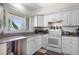 Bright kitchen features white cabinets, granite countertops, and a stainless steel sink under a window at 2518 Keen Park Dr, Largo, FL 33771