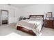 A sunlit bedroom with a large bed, carpet floors, and a full length mirror reflecting the space at 34196 Polacca Ln, Wesley Chapel, FL 33543