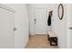 Bright entryway with clean, neutral decor, tiled floor, coat hooks, bench and ample lighting at 34196 Polacca Ln, Wesley Chapel, FL 33543