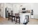 Bright kitchen with white cabinets, stainless steel appliances, and a quartz countertop island with seating at 34196 Polacca Ln, Wesley Chapel, FL 33543