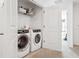 Convenient laundry room with modern washer and dryer, white cabinets, and neutral tile flooring at 34196 Polacca Ln, Wesley Chapel, FL 33543