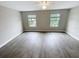 Spacious bedroom featuring two windows and wood-look flooring at 3926 Cat Mint St, Tampa, FL 33619