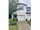 Charming townhome featuring a one-car garage, lovely landscaping, and light-colored exterior at 3926 Cat Mint St, Tampa, FL 33619