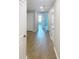 Bright hallway with multiple doors and wood-look flooring at 3926 Cat Mint St, Tampa, FL 33619