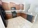 Well-lit kitchen with granite countertops, dark wood cabinets, and black appliances at 3926 Cat Mint St, Tampa, FL 33619