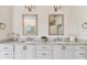 Stylish double vanity bathroom with framed mirrors, marble countertops, and white cabinetry at 4012 W Obispo St, Tampa, FL 33629