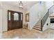Bright foyer features a wooden front door, elegant staircase, and neutral tile flooring at 4012 W Obispo St, Tampa, FL 33629
