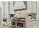 Gourmet kitchen featuring stainless steel appliances, a marble backsplash, and custom cabinetry at 4012 W Obispo St, Tampa, FL 33629