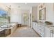 An elegant bathroom with a soaking tub, marble countertop vanities and neutral tile floors at 4012 W Obispo St, Tampa, FL 33629