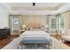 A serene main bedroom with tray ceilings, a decorative rug and patterned wallpaper at 4012 W Obispo St, Tampa, FL 33629