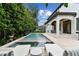 Relaxing backyard featuring a swimming pool, spa, and landscaped with privacy hedges at 4012 W Obispo St, Tampa, FL 33629