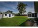 Expansive backyard with lush green grass, a shed, and an enclosed back porch at 5018 Pine St, Seffner, FL 33584