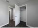 A secondary bedroom with new dark floors, gray paint, and a closet at 5018 Pine St, Seffner, FL 33584