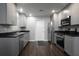 Contemporary kitchen boasts stainless steel appliances, dark countertops and elegant gray cabinetry at 5018 Pine St, Seffner, FL 33584