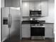 Modern kitchen featuring stainless steel appliances, gray cabinets, and dark countertops at 5018 Pine St, Seffner, FL 33584