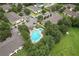 Aerial view of a community with swimming pool, parking, and lush trees at 6332 Timberly Ln, Zephyrhills, FL 33542