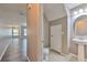 Neutral bathroom with toilet and pedestal sink near hardwood floors, with an open concept living area in the background at 6332 Timberly Ln, Zephyrhills, FL 33542