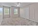 Spacious bedroom with carpet floors, closet, and two windows, allowing ample natural light at 6332 Timberly Ln, Zephyrhills, FL 33542